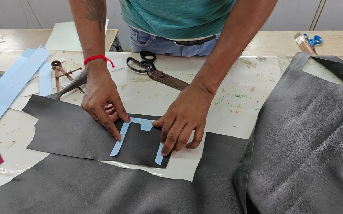 Placing the pattern on a black hide before hand cutting, Revati Craft, Kolkata