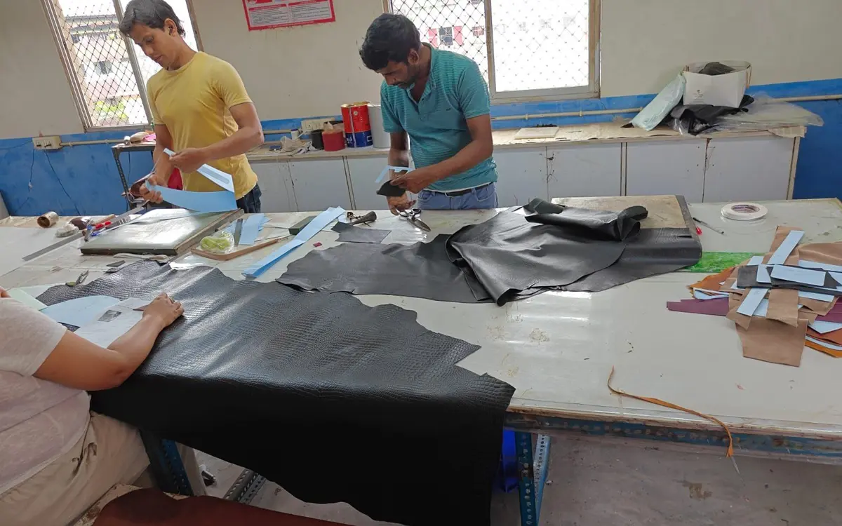 Sampling table at Revati Craft, Bantala: croc-embossed hide being cut for a first sample